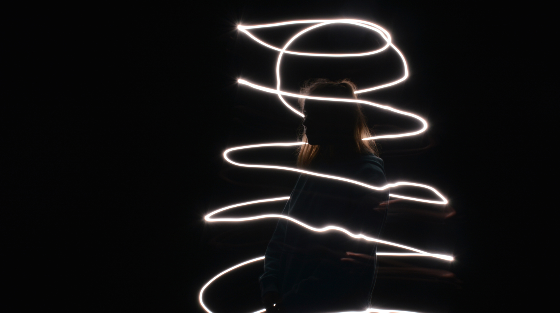 photo en light painting d'une femme encerclé dans un tube en anneau de lumière