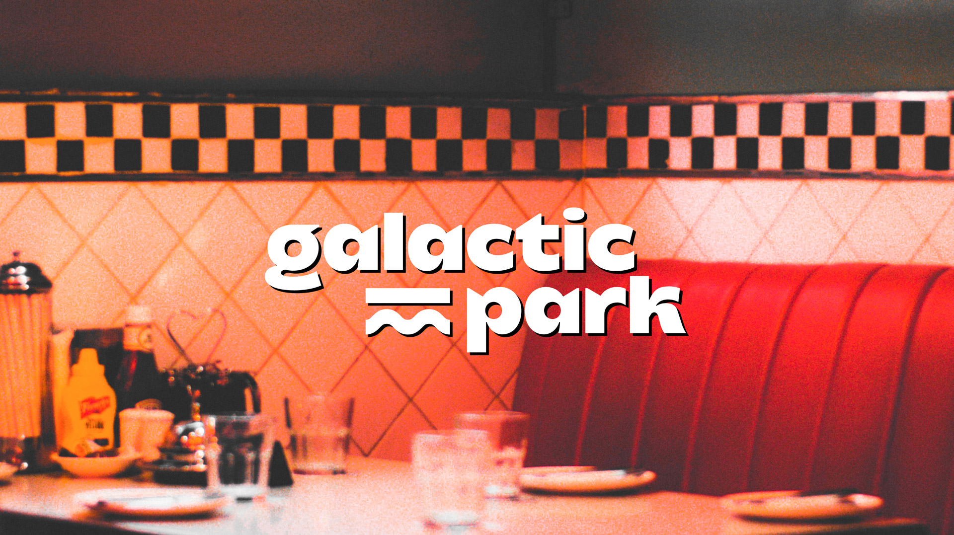 Identité visuelle vintage dont logotype du Galactic Park. Typographie déséquilibrée, mouvementée, avec une ombre. Le logo est placé sur une image d'un dinner américain, avec du grain photo.