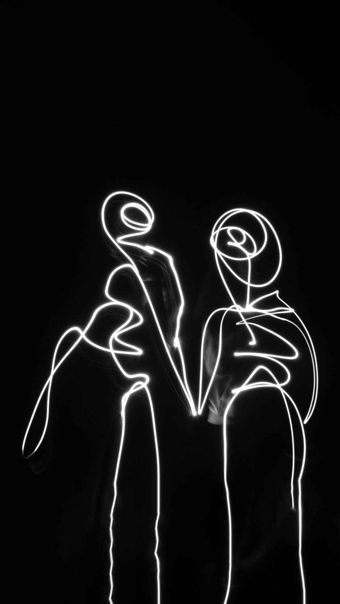 Photographie en lightpainting d'un couple se tenant la main évoquant l'amour.