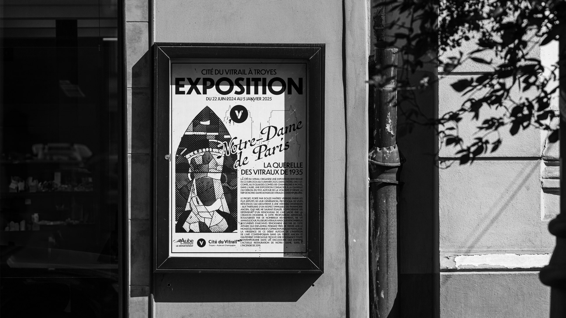 Affiche publicitaire dans un cadre à côté d'une porte sur une façade extérieure